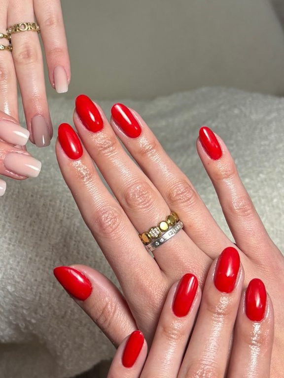 Zwei Hände mit Modellage, links milchiges Nude, rechts kräftiges Rot